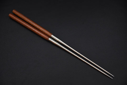 Baguettes japonaises Moribashi en acier inoxydable et bois satiné sur fond noir.