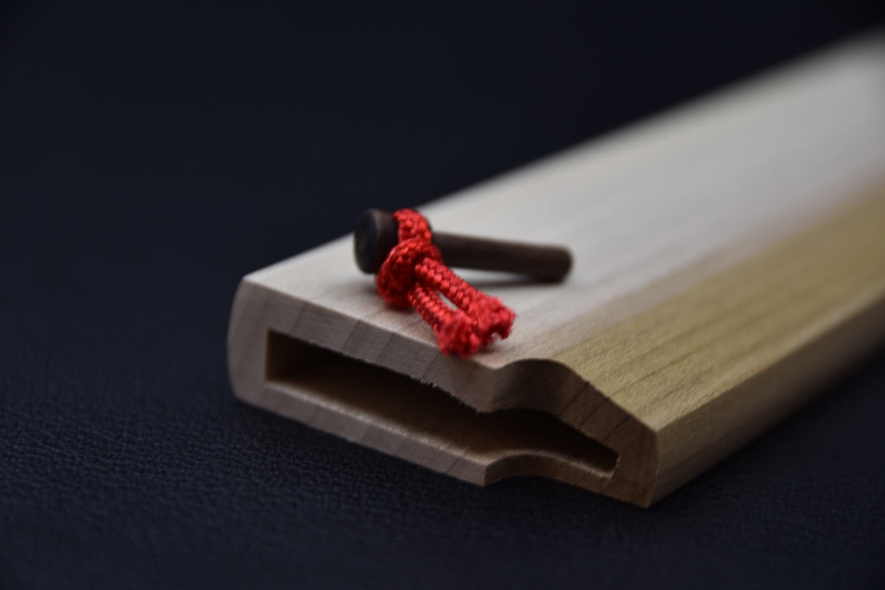 Gros plan sur l’extrémité de la saya et le bois de magnolia