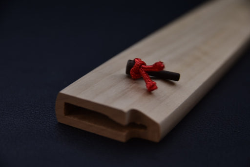 Gros plan sur le système de maintien en bois avec cordon rouge du saya Hitohira.