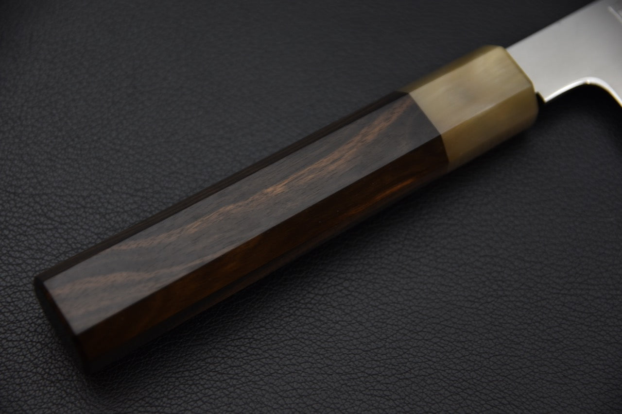 Gros plan sur le manche octogonal en ébène et la virole en corne.