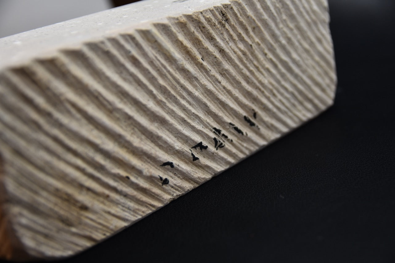 Détail du flanc scié et strié de la pierre naturelle Natsuya pour l’aiguisage d’un couteau japonais.