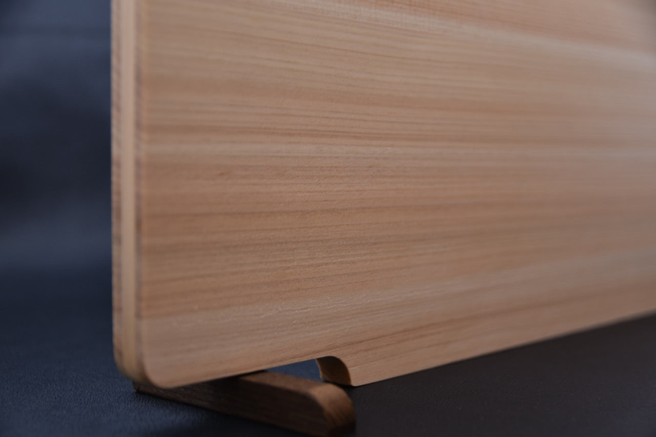 Vue latérale de la planche à découper en hinoki montrant son profil fin et le support en bois de rose.