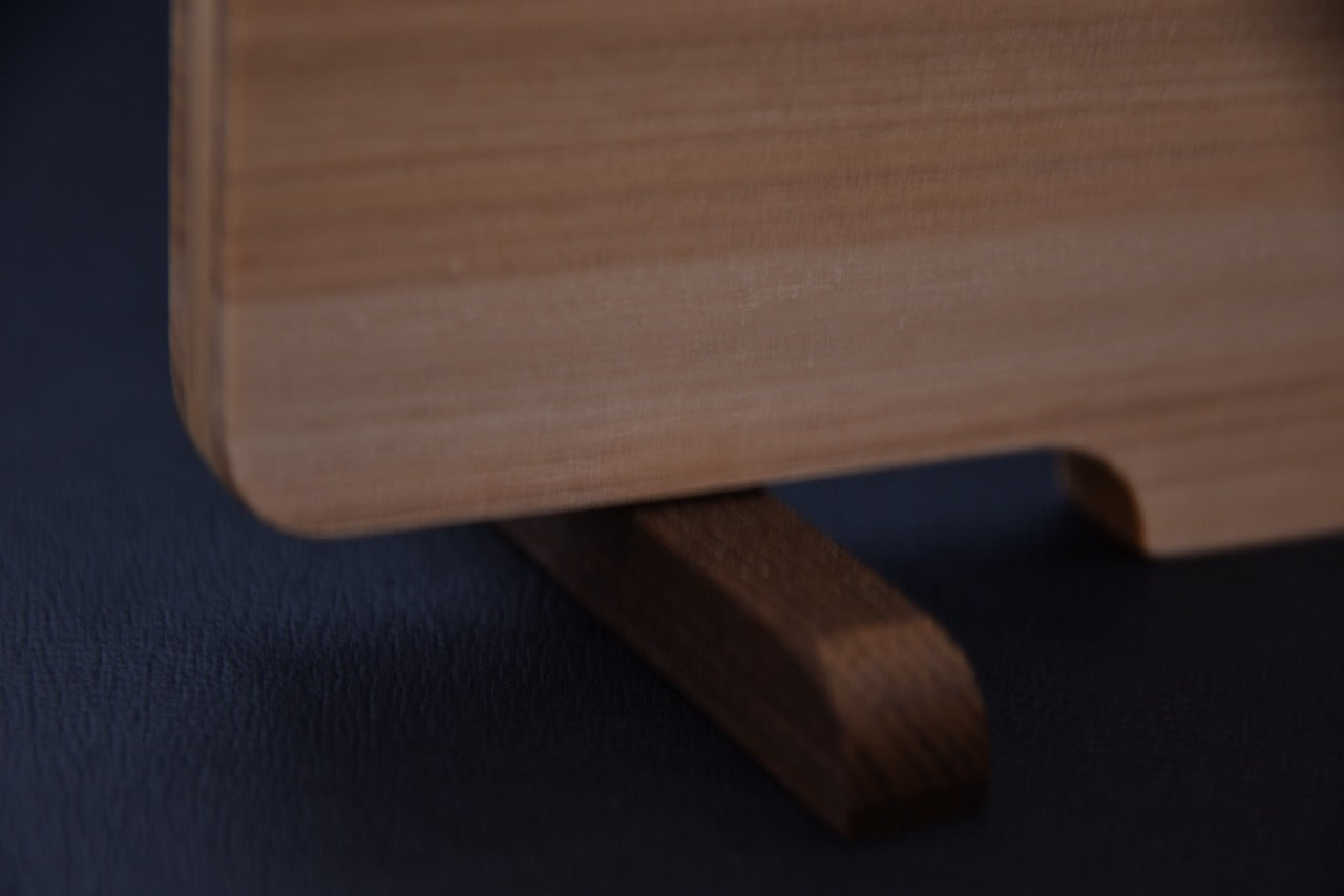 Pied rotatif en bois de rose permettant de poser la planche à découper japonaise verticalement.