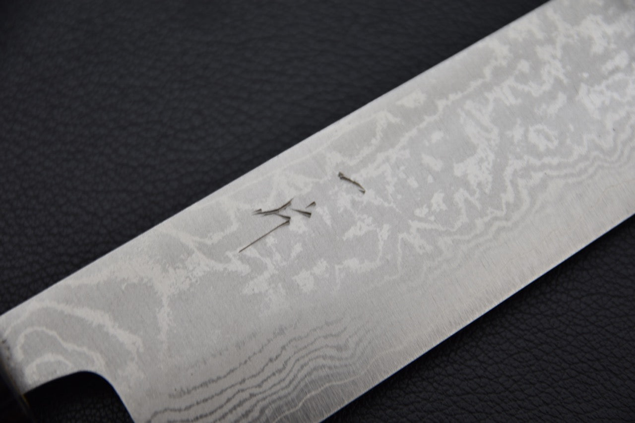 Vue rapprochée des kanji gravés sur la lame du Sujihiki Hitohira Setsu