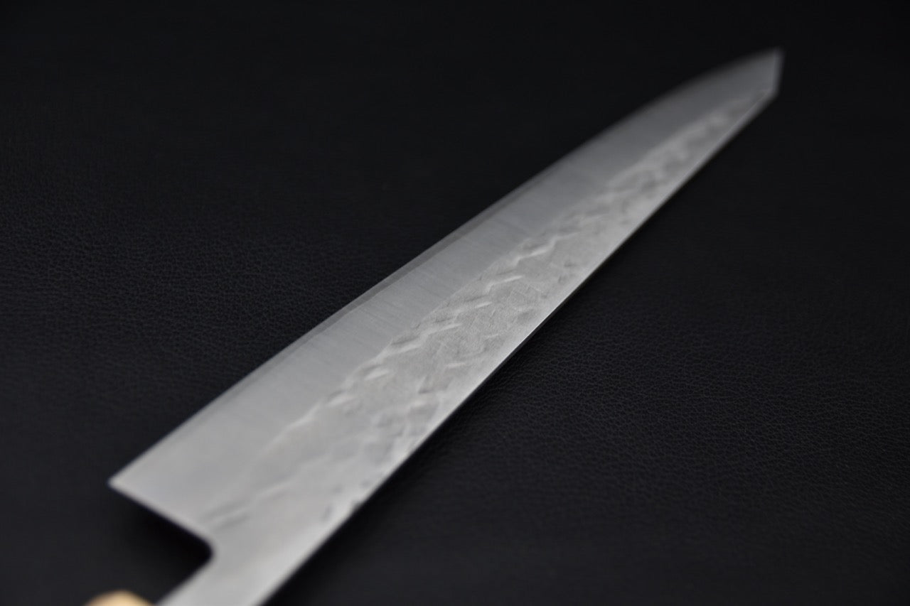 Gros plan sur la lame du couteau japonais sujihiki Hitohira TD SLD montrant le motif martelé.