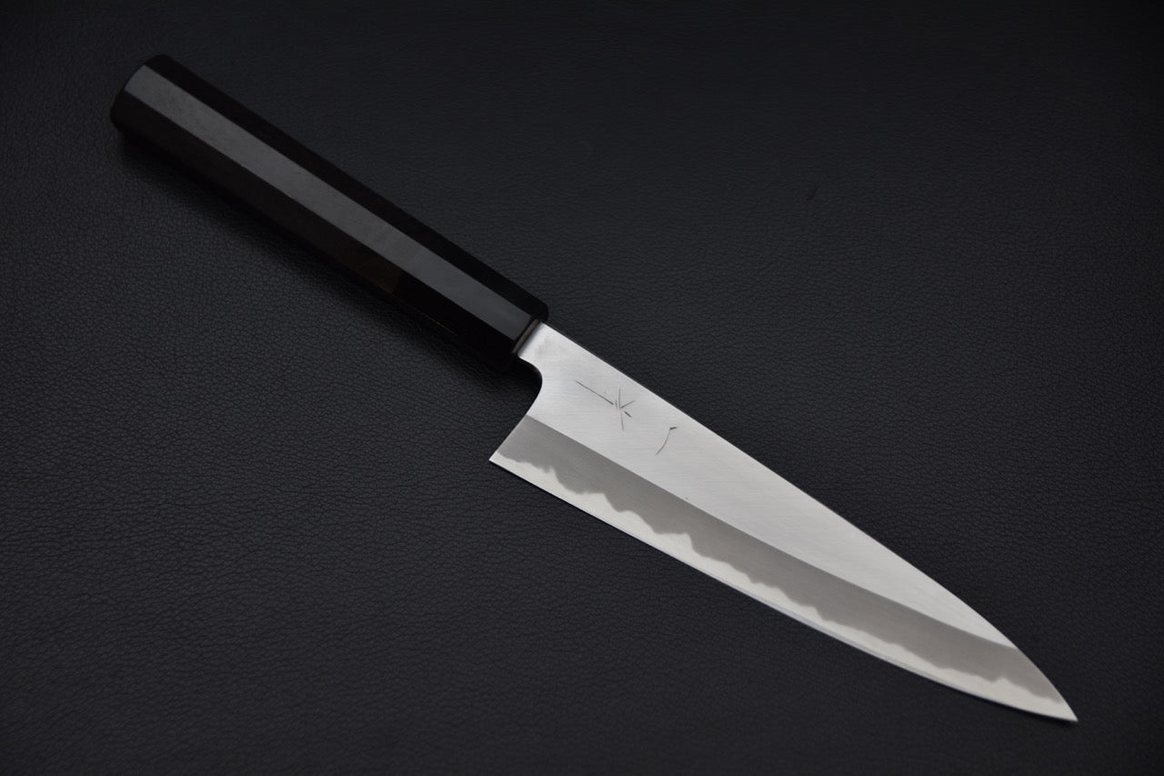 Couteau japonais Petty 165mm en acier Aogami #1, manche en ébène octogonal sur fond noir.