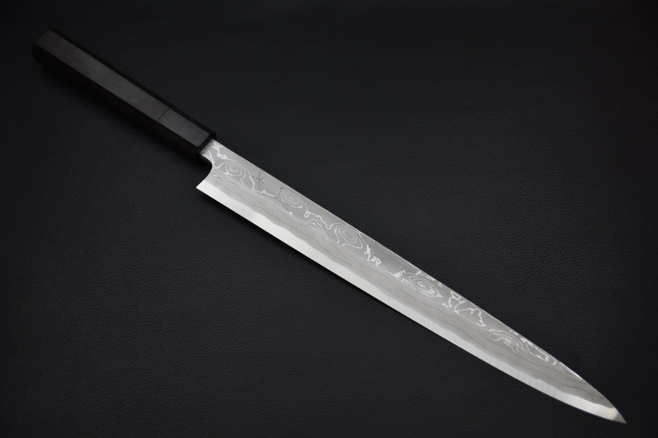 Couteau japonais Yanagiba en acier damassé avec manche noir sur fond sombre