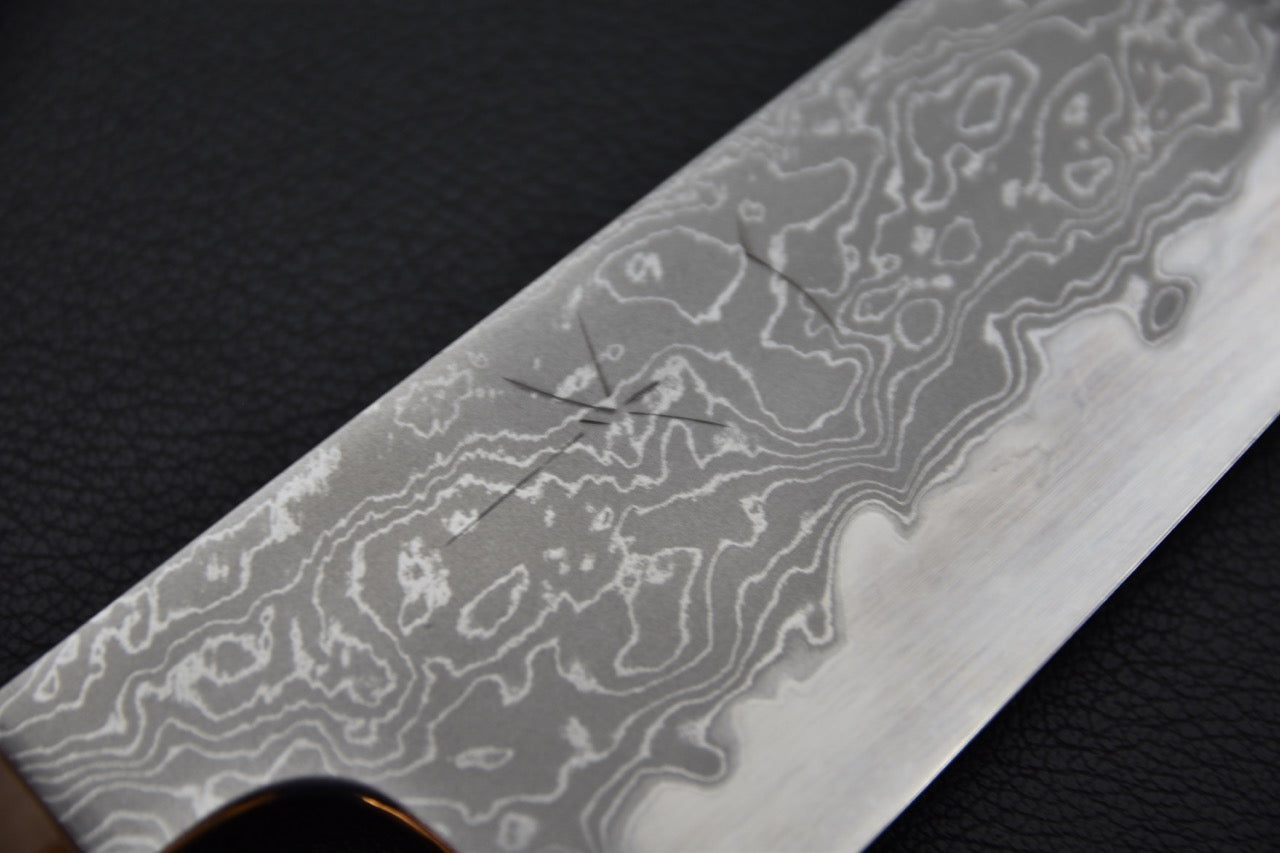 Gros plan sur le motif damassé de l'acier, révélant les couches repliées