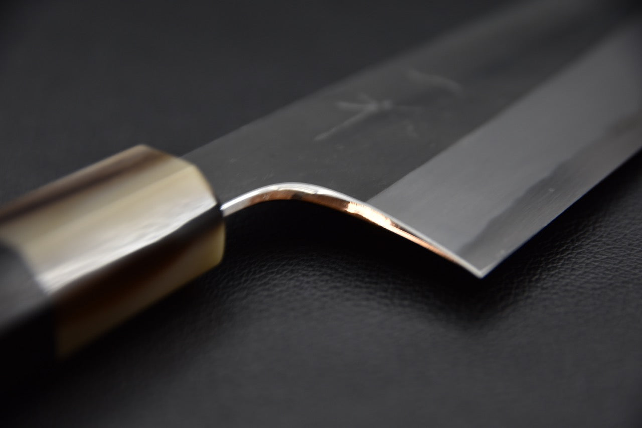 Courbe soignée entre la soie et la lame, finition polie.
