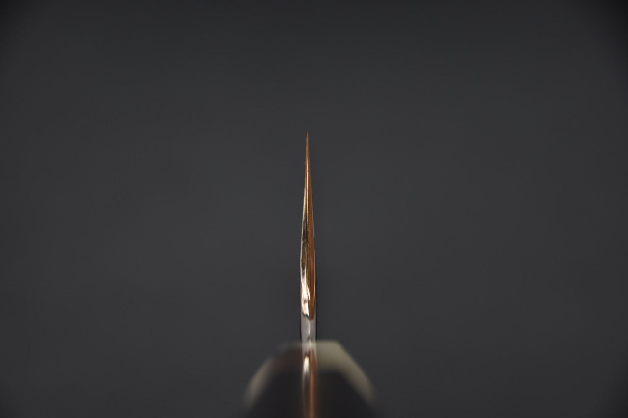 Courbe soignée entre la soie et la lame, finition polie.