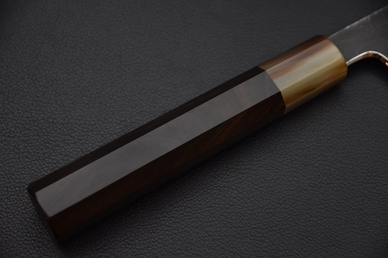 Poignée sombre en bois d’ébène poli à facettes nettes.