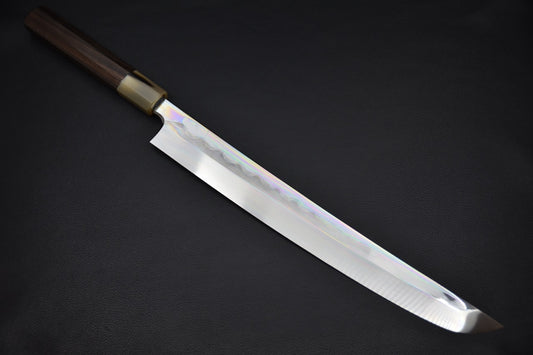 Japanese sakimaru yanagiba knife with a long polished blade and dark wa-style handle, displayed on a dark background.