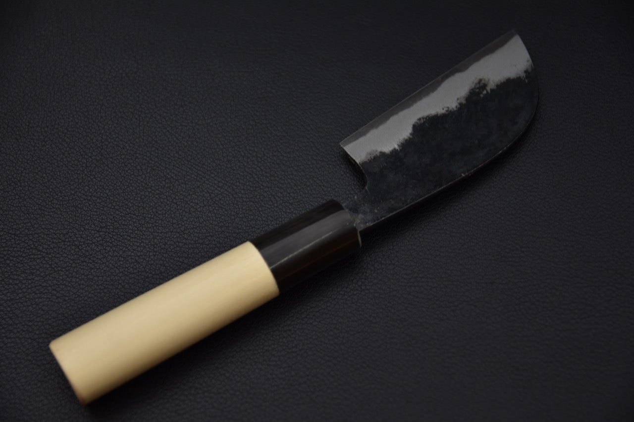 Vue inversée du couteau, exposant la courbe arrondie de la lame.