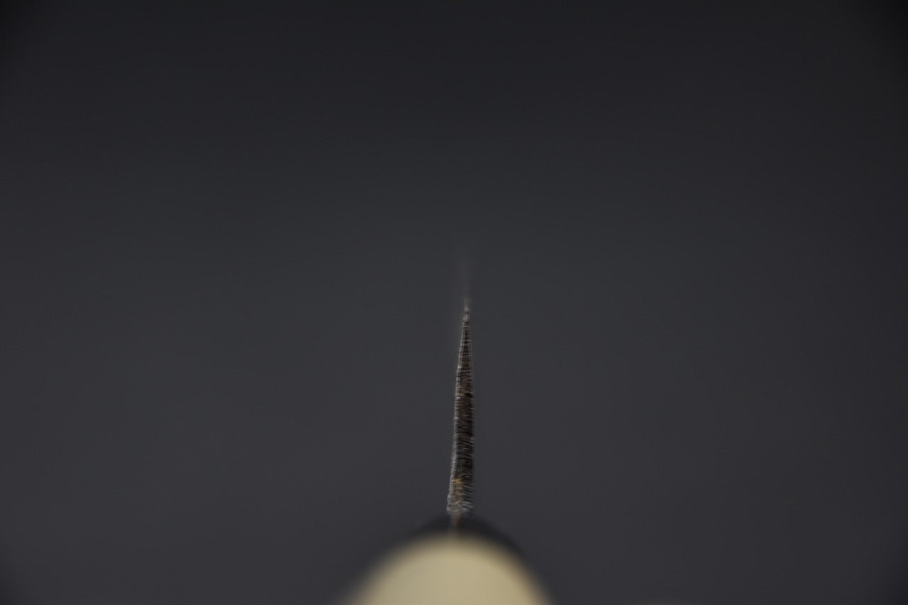 Photo en plongée sur la lame, illustrant l’extrême finesse du biseau.