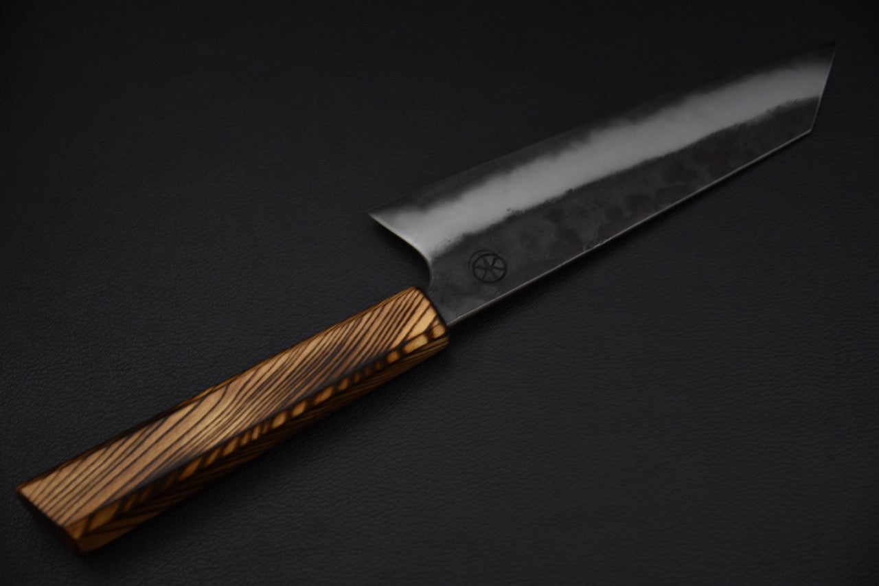 Couteau japonais Bunka en acier carbone 125Cr1, gros plan du biseau poli et de la transition avec la finition kurouchi.