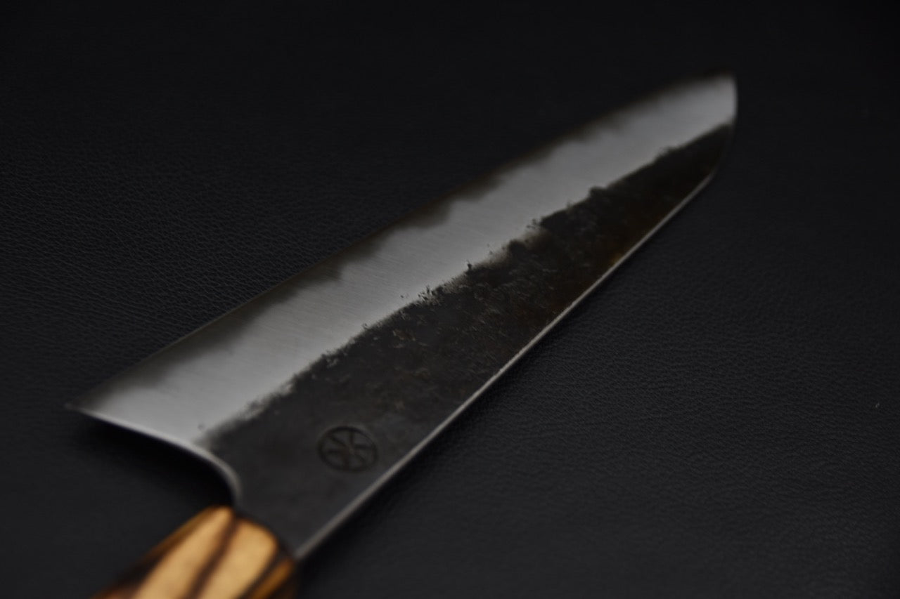 Couteau japonais Gyuto en acier carbone 125Cr1, vue rapprochée de la lame kurouchi et de la pointe effilée.