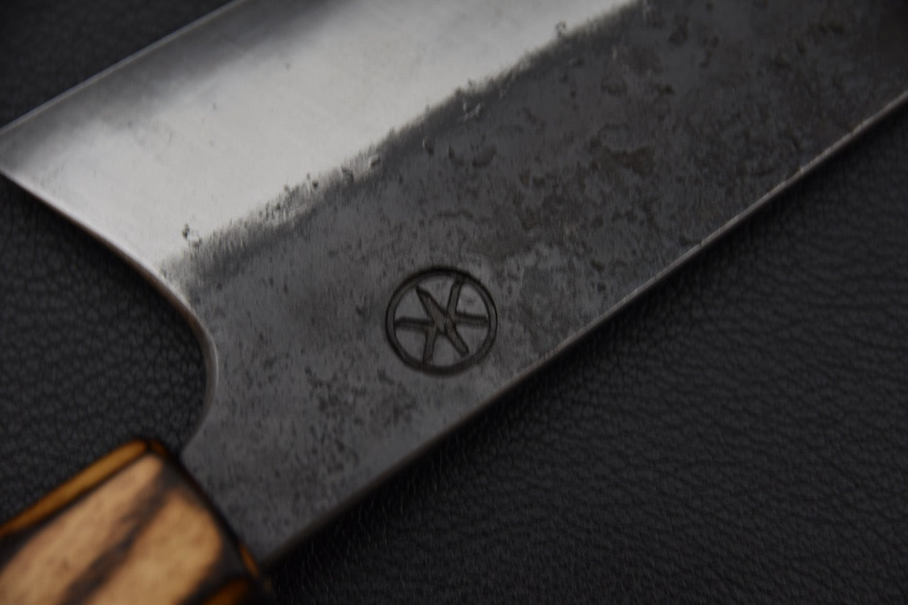 Couteau japonais Gyuto Kaizen x Stay Sharp, gros plan du poinçon artisanal près du talon de la lame.