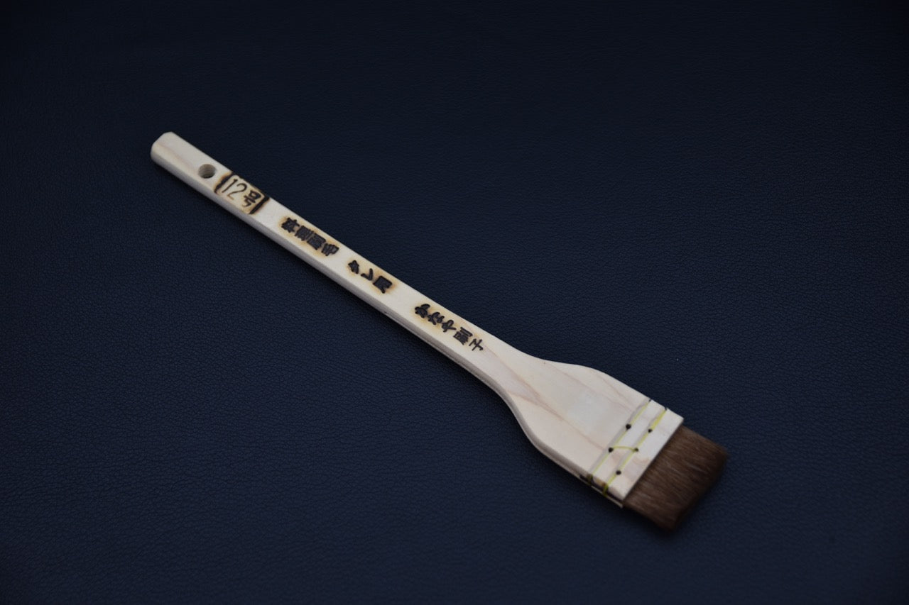 Traditional Japanese wooden basting brush with natural horsehair bristles, shown on a dark background.