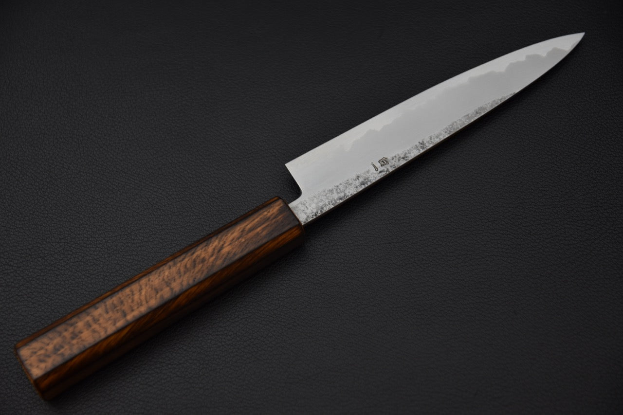 Vue complète du couteau japonais Petty avec manche octogonal en bois de chêne brûlé.