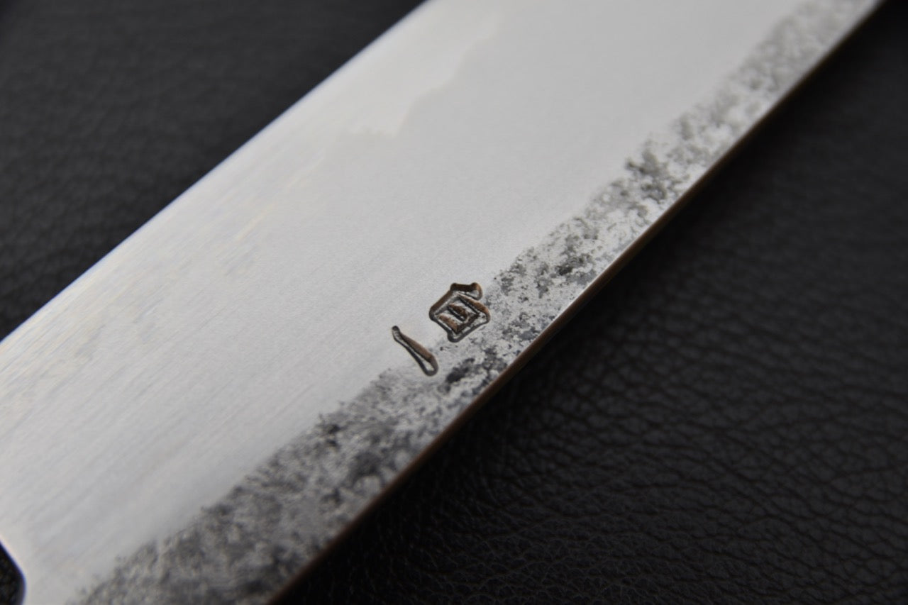 Gros plan sur le manche octogonal en chêne brûlé du couteau japonais Petty 150 mm.