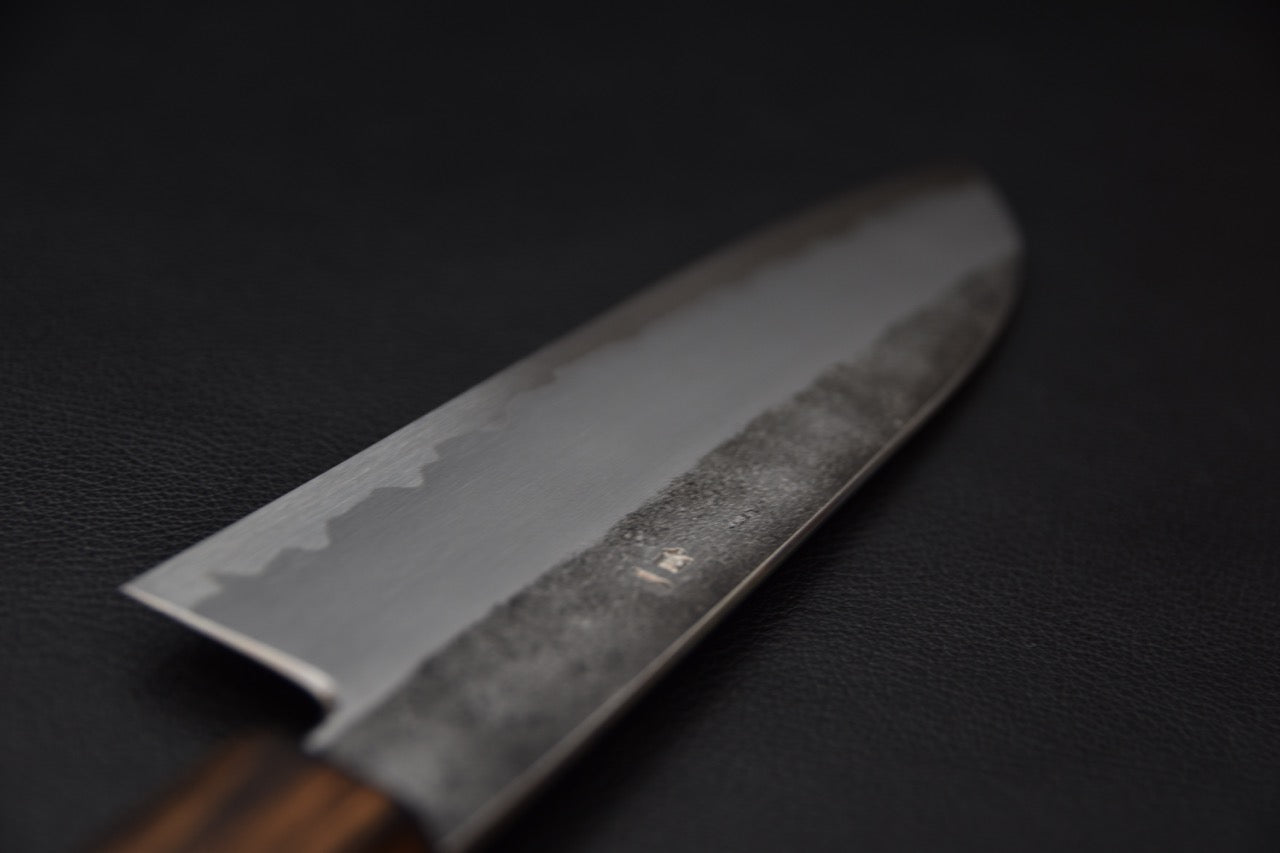 Couteau japonais Santoku pris de profil, révélant la finesse du biseau.