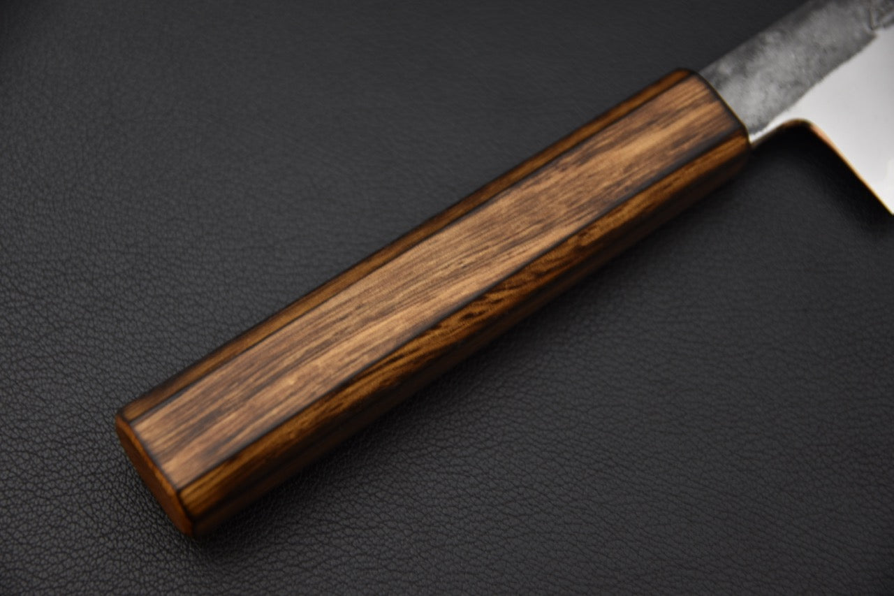 Pointe effilée d’un couteau japonais Santoku vue depuis le dos de la lame.