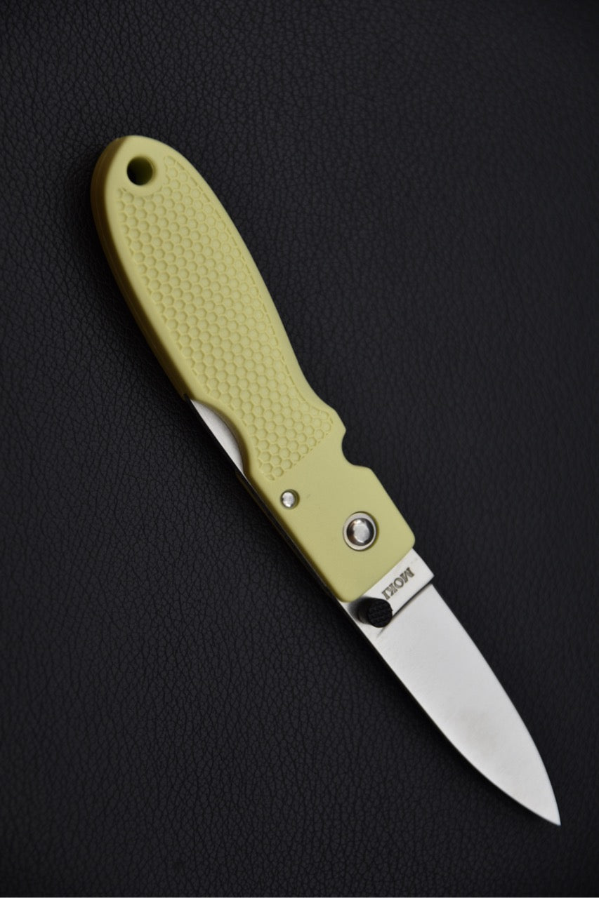 Vue plongeante du couteau pliant MOKI Coupe avec manche texturé en Grilon vert crème