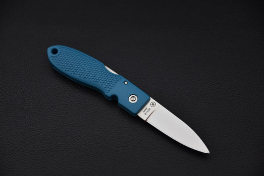 Couteau pliant MOKI Coupe avec lame déployée et manche bleu-gris en Grilon sur fond noir.