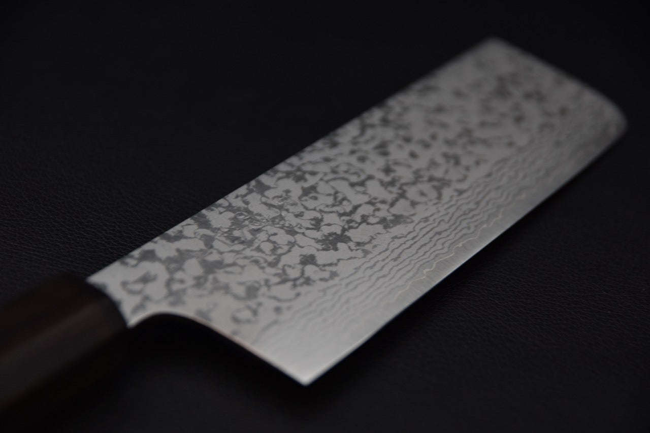 Lame du couteau japonais nakiri VG7, motif damassé en gros plan.