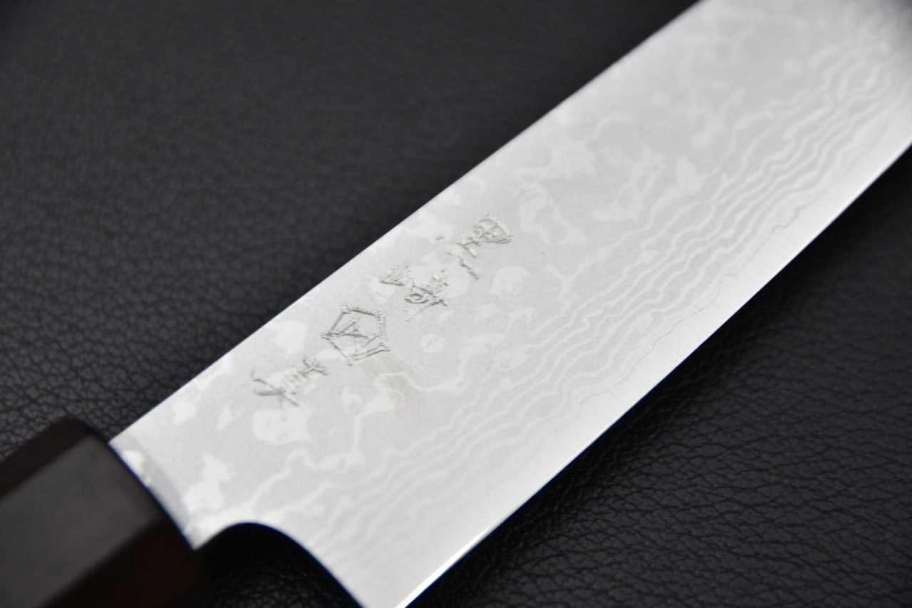 Gros plan sur le tranchant du couteau japonais VG7 Damascus