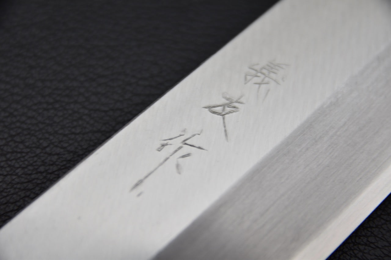 Gros plan sur la lame gravée d'un couteau japonais Usuba en acier shirogami