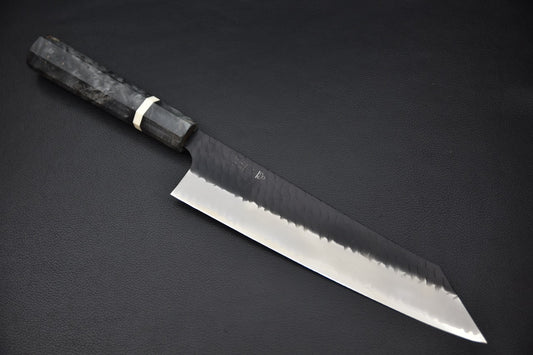 Couteau japonais Gyuto Kiritsuke 240mm Nigara Hamono, lame SG2 finition kurouchi tsuchime, vue complète sur fond noir.