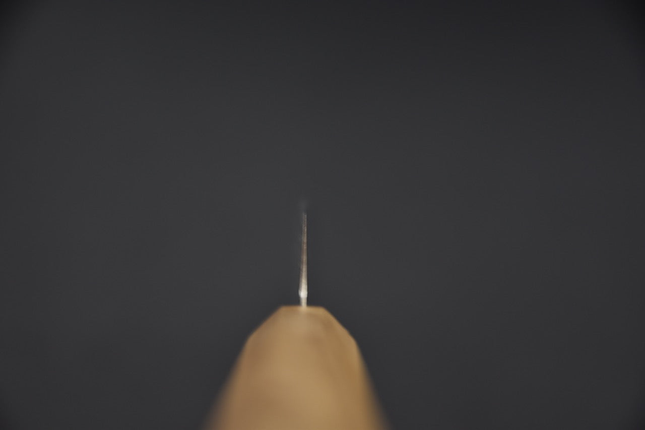 Vue du couteau depuis la pointe, soulignant la finesse du biseau