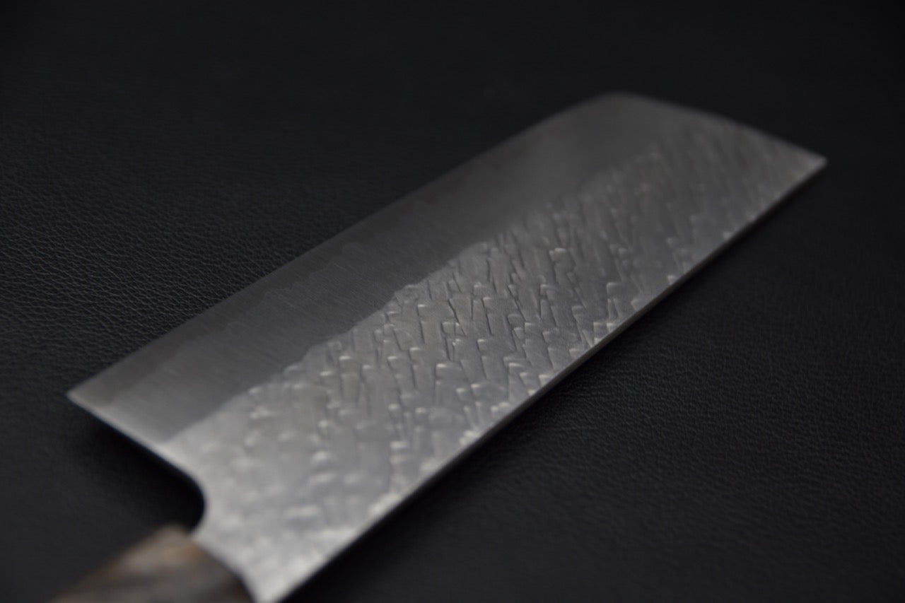 Texture martelée tsuchime sur la lame du couteau japonais Nakiri Saji Hamono STRIX.