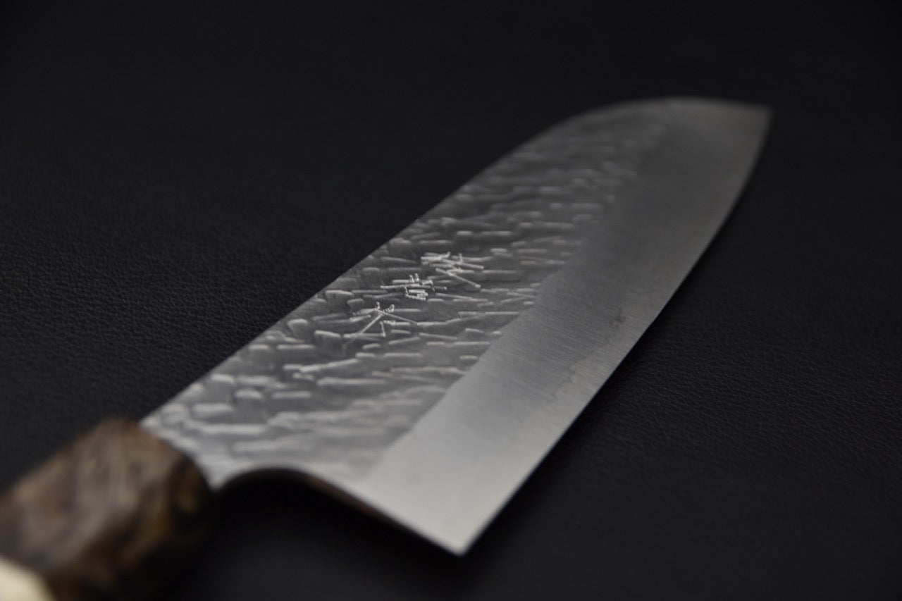Détail de la lame martelée du couteau japonais Saji Hamono STRIX Tsuchime, inscription gravée visible.