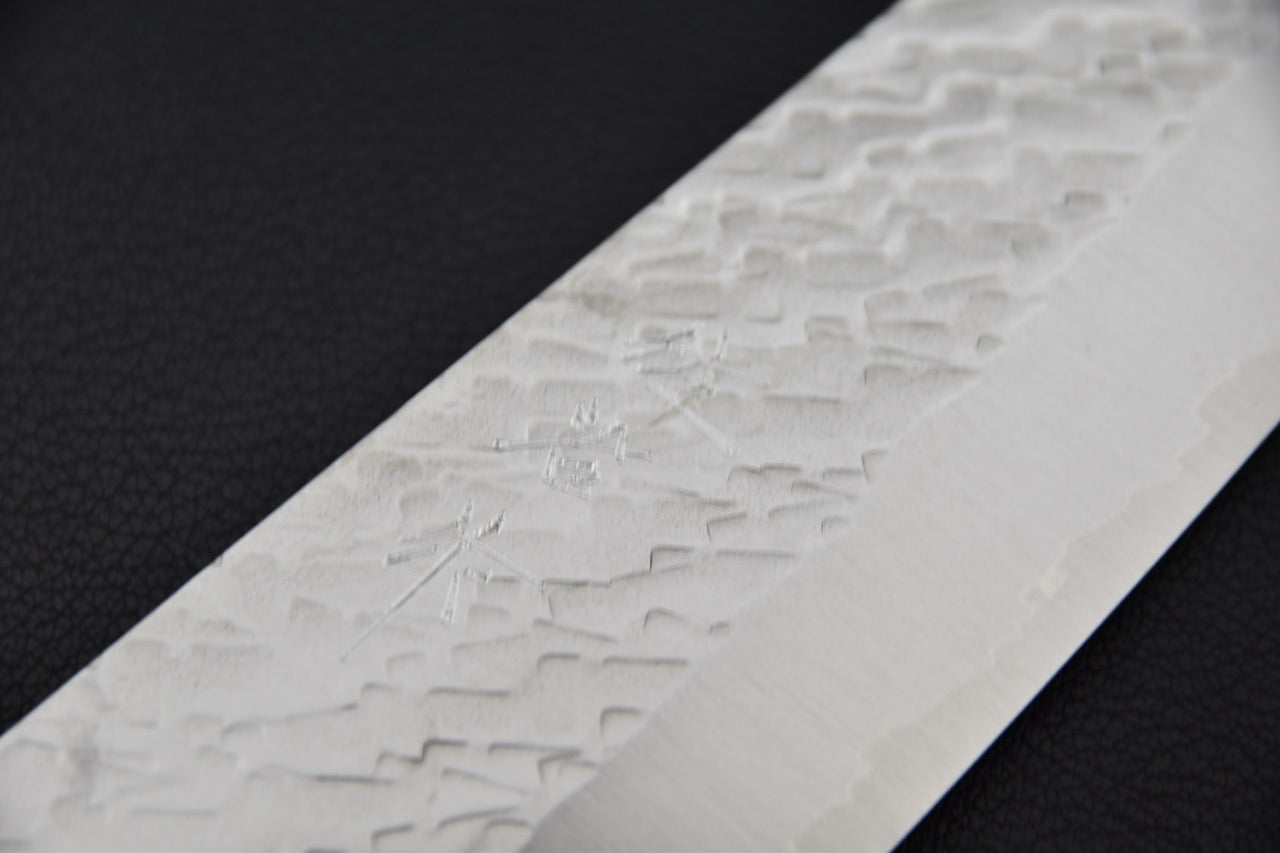 Gros plan sur la texture tsuchime de la lame du couteau japonais Santoku Saji Hamono STRIX.