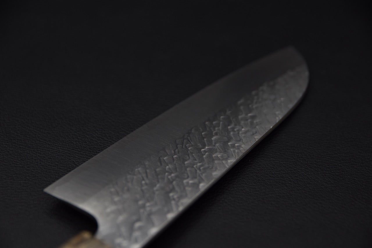 Détail de la zone de coupe de la lame martelée du couteau japonais Santoku.