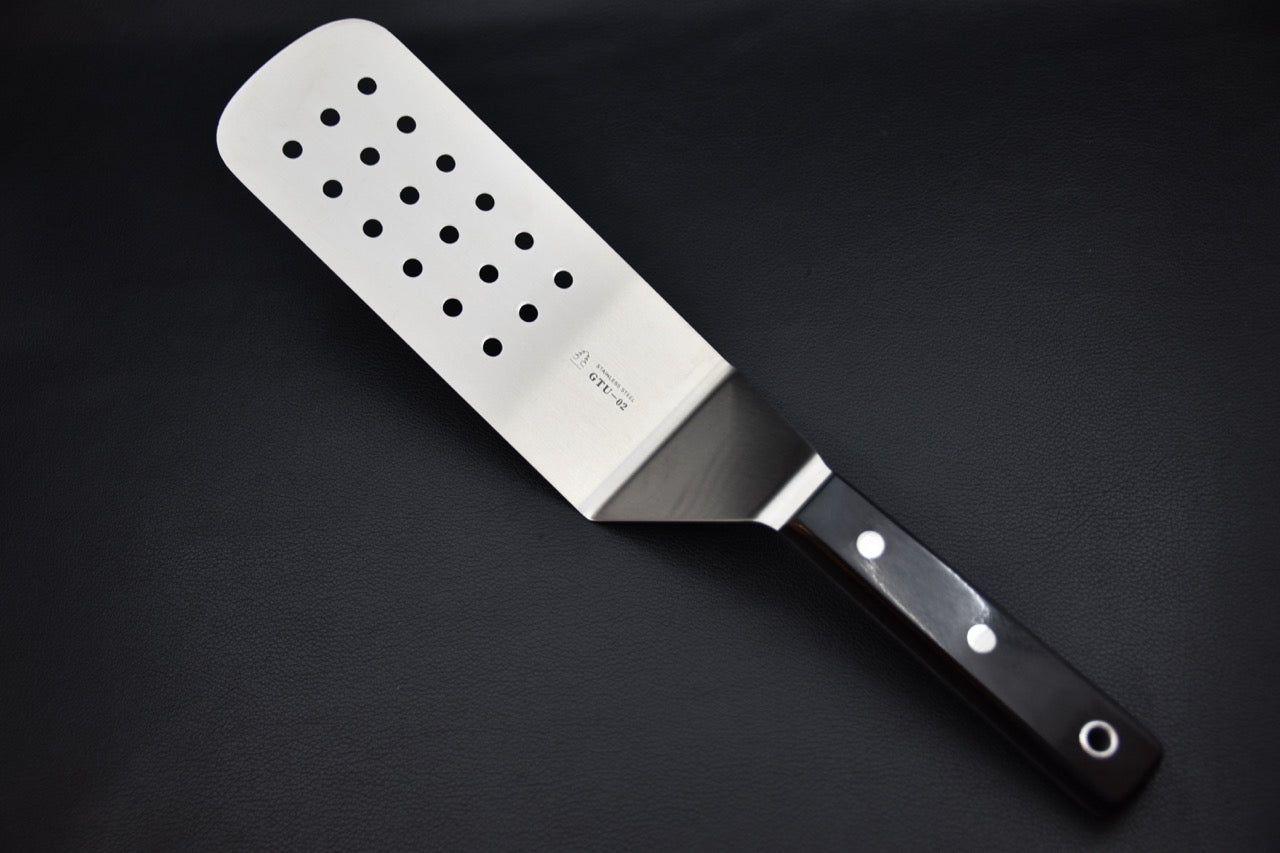 Spatule perforée Sekishin GTU-02 en acier inoxydable avec manche noir, accessoire japonais pour cuisine au couteau japonais — Stay Sharp Montréal.