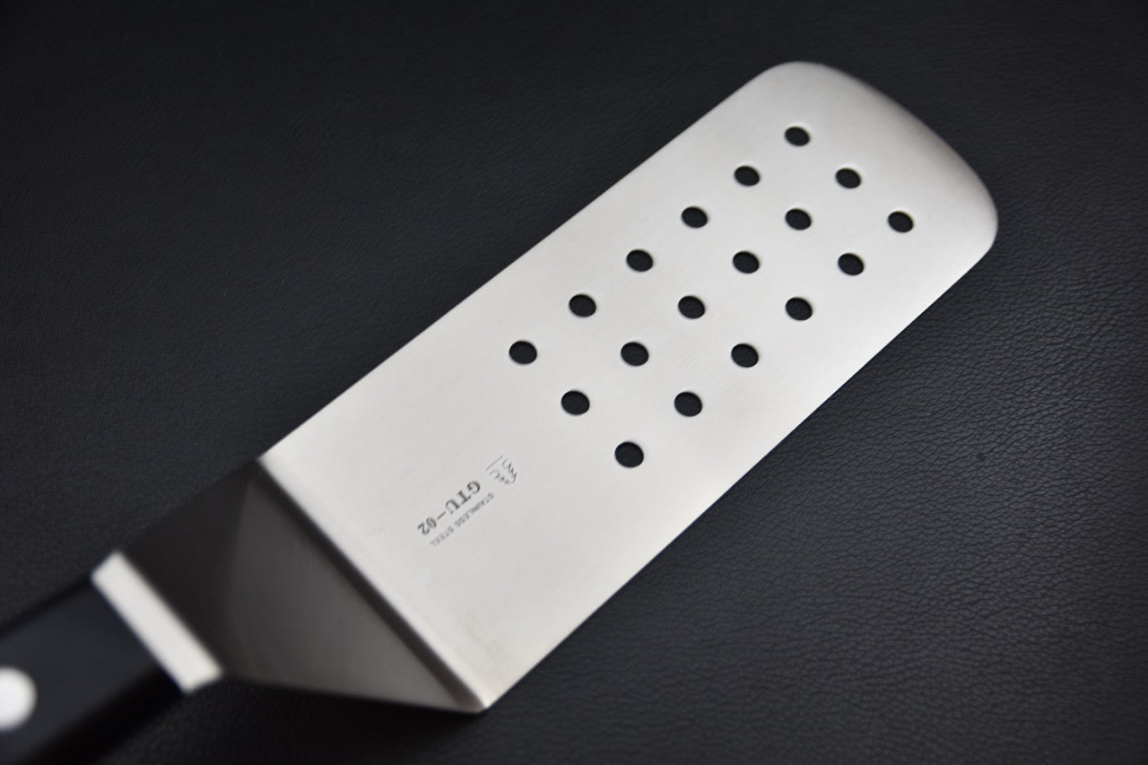 Vue rapprochée de la spatule perforée Sekishin GTU-02 en acier inoxydable, large surface de 75 mm pour cuisine au couteau japonais.