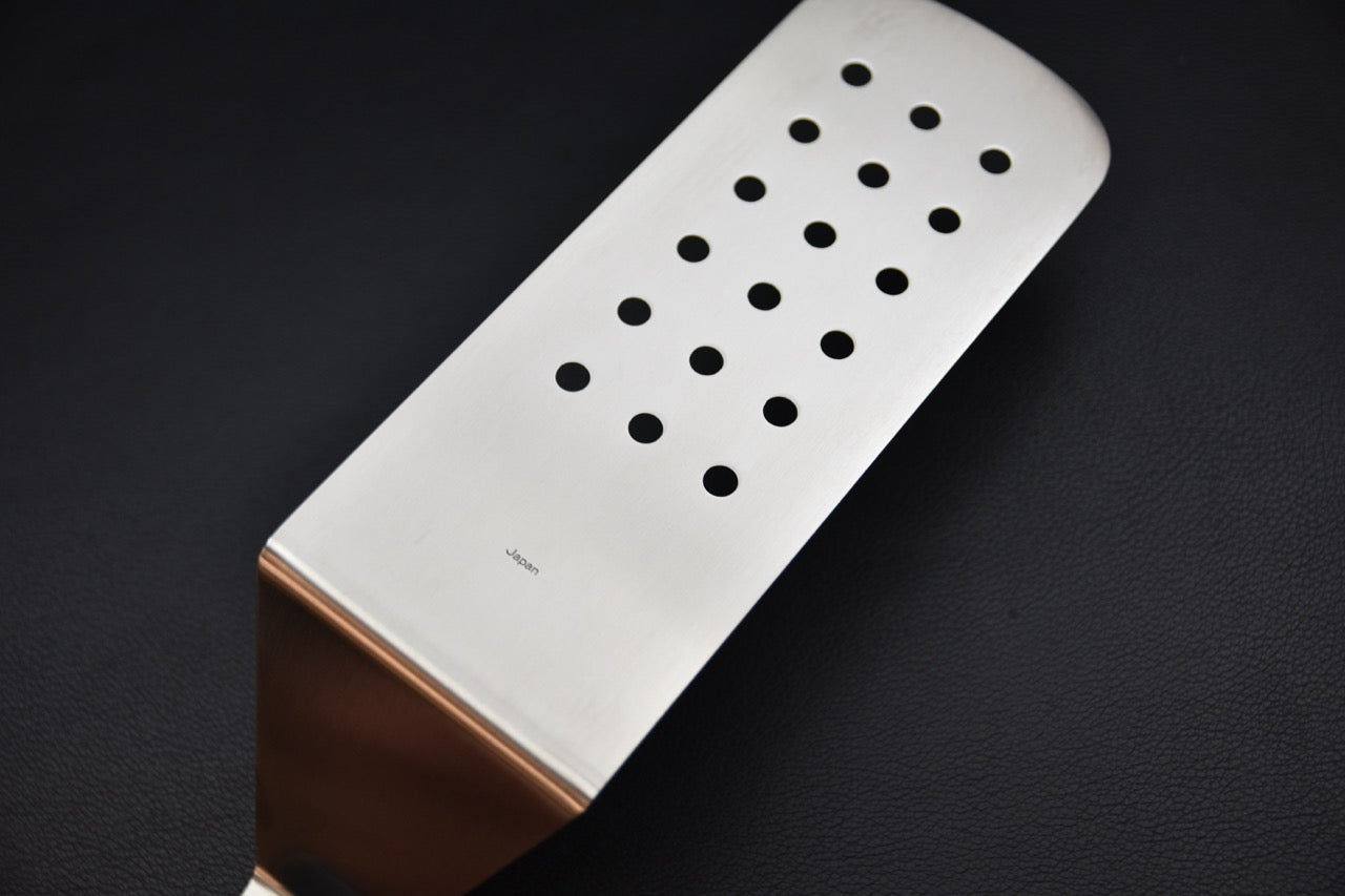 Dos de la spatule perforée Sekishin GTU-02 fabriquée au Japon, surface inoxydable avec perforations pour égoutter les aliments.
