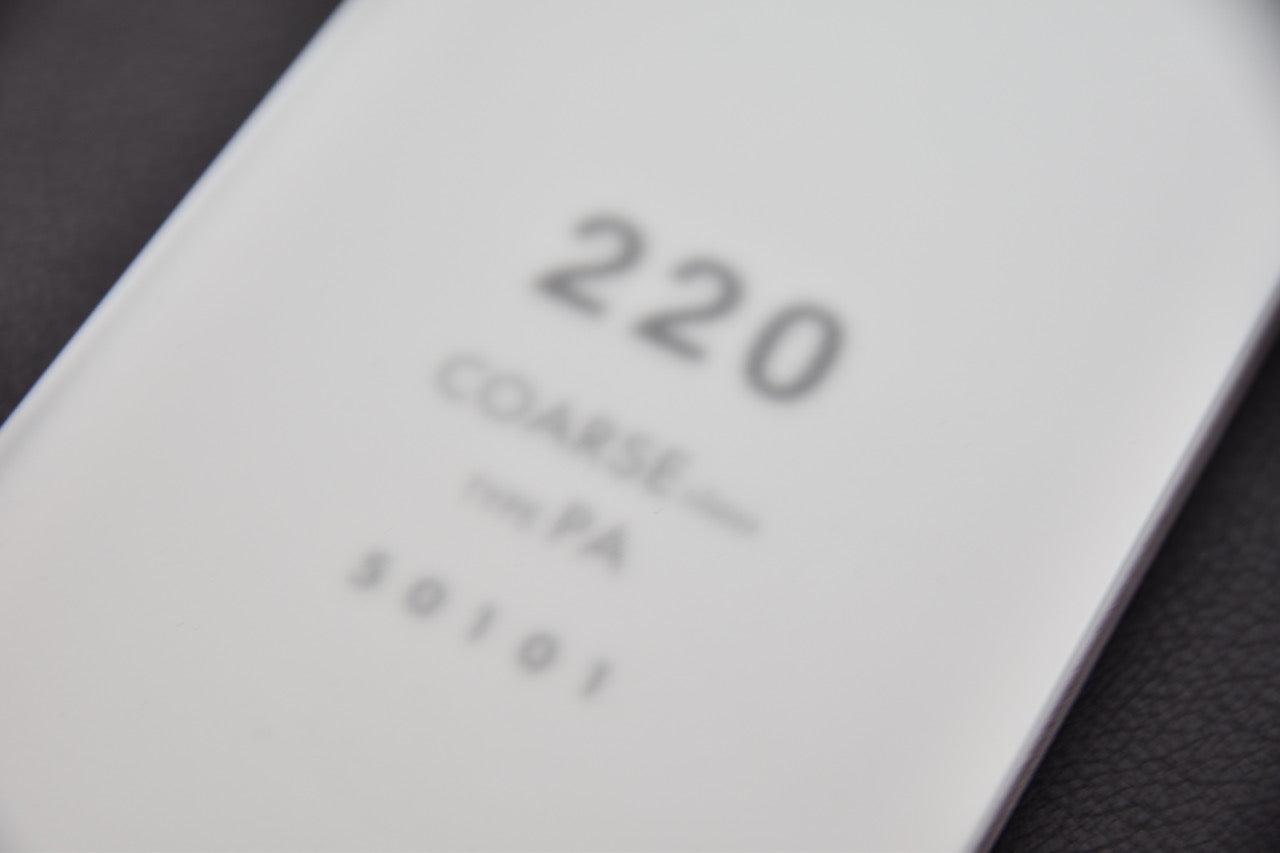 Grit 220 visible sur une pierre à aiguiser Shapton Glass japonaise, vue rapprochée.

