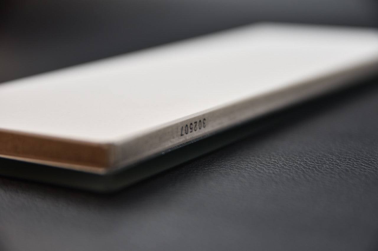 Vue latérale de la pierre à aiguiser Shapton Glass #3000 avec base en verre et code gravé.

