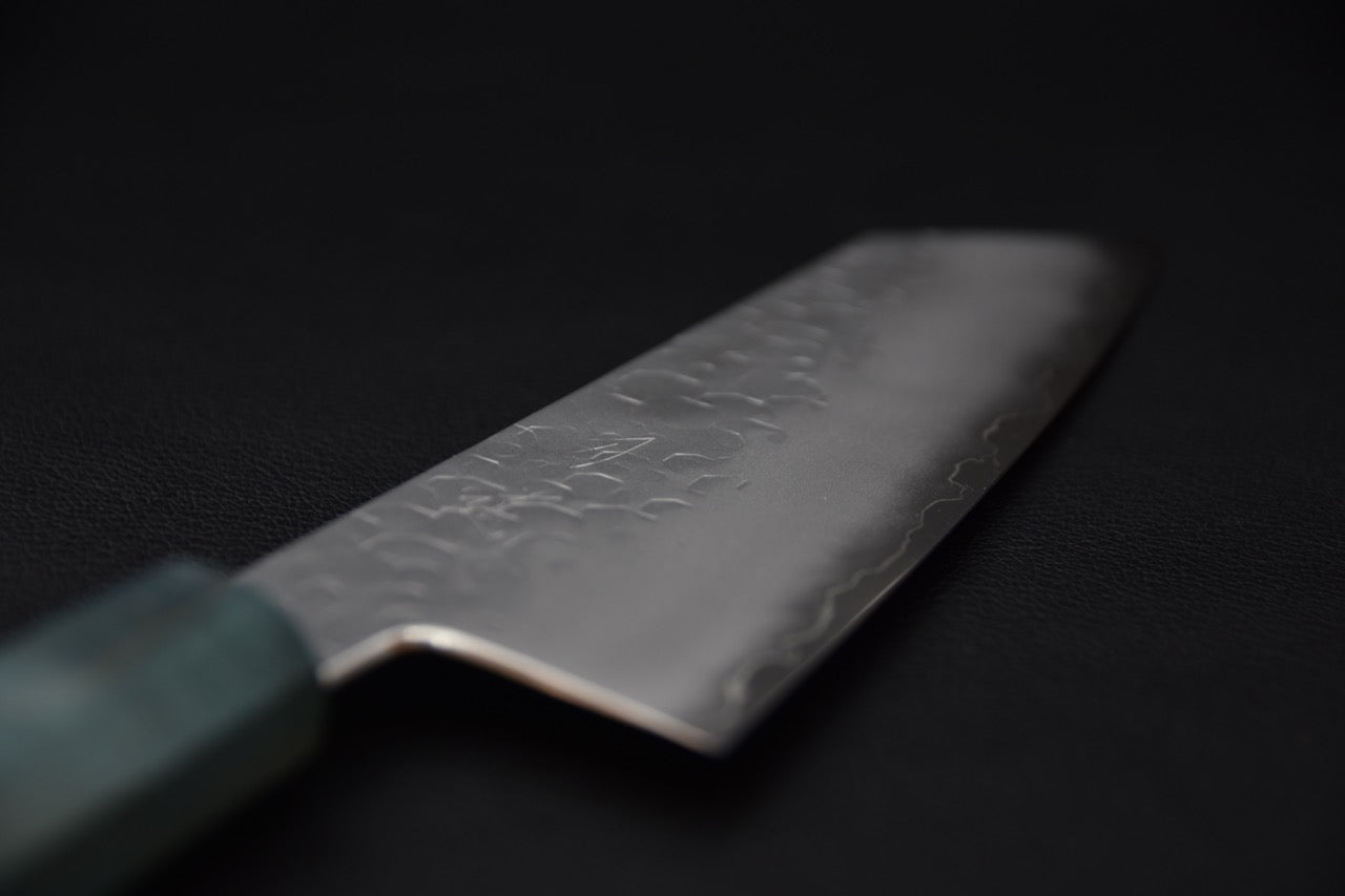 Gros plan sur la lame de couteau japonais Bunka 180mm montrant la finition martelée tsuchime.