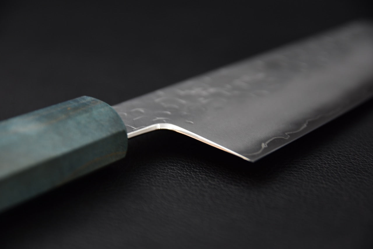 Pointe acérée et finition soignée de la lame d’un couteau japonais Bunka en acier SG2.