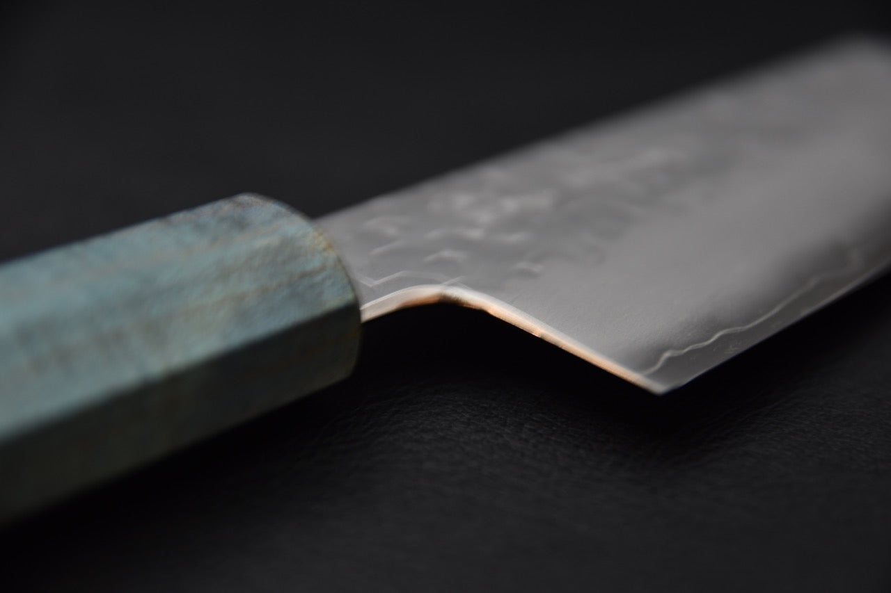 Vue de la colonne vertébrale fine et équilibrée d’un couteau japonais Ko-Bunka artisanal.