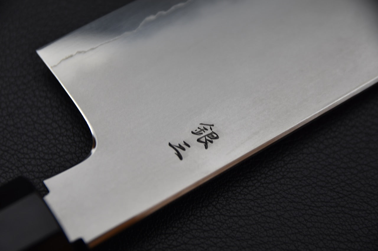 Kanji gravés en noir sur la lame côté ura du couteau Tetsujin Ginsan.