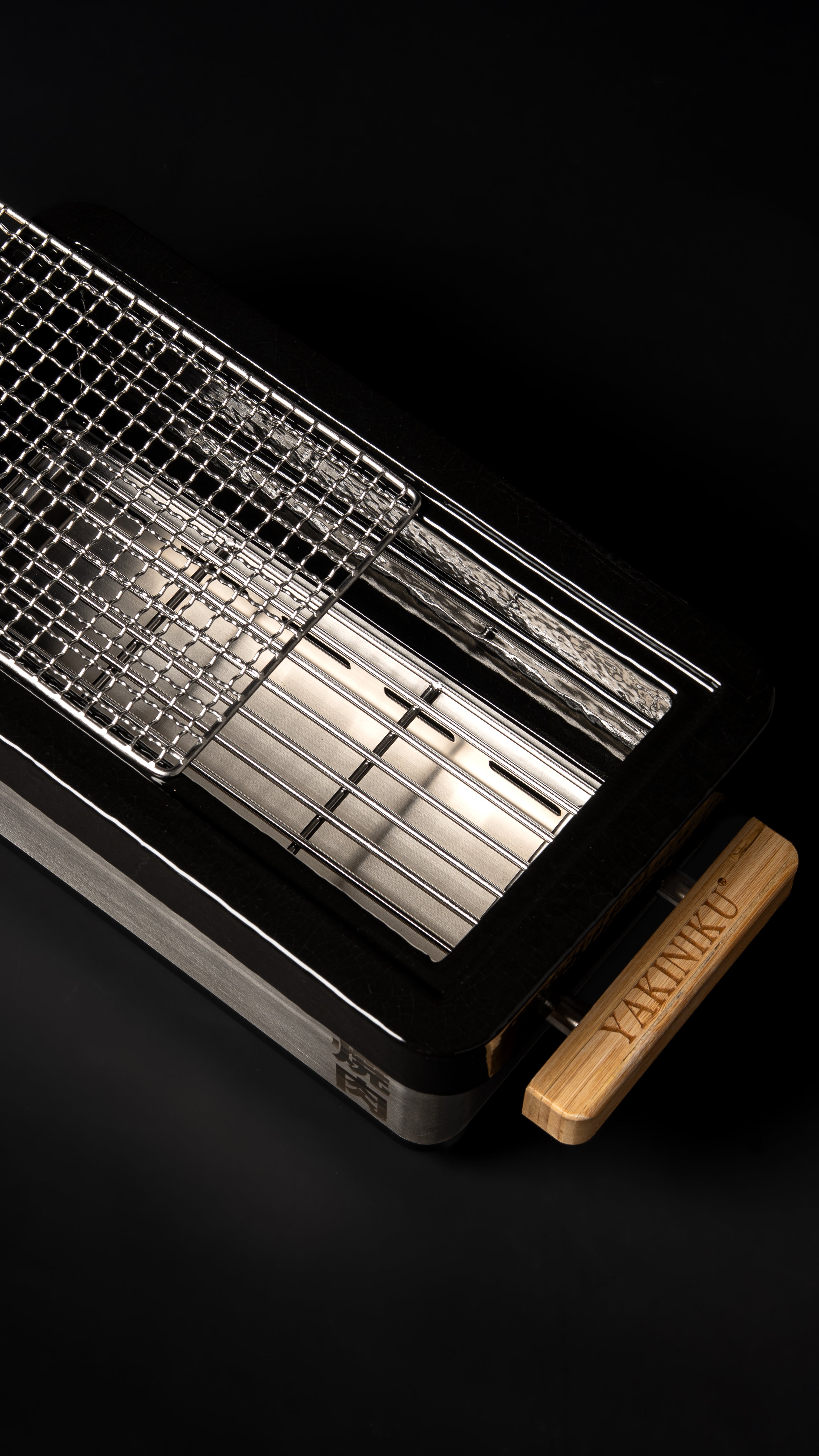 Japanese grill YAKINIKU Shichirin PRO opened to show interior charcoal support and rectangular cooking surface.