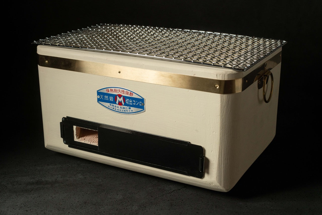 Yakitori Shichirin Petit rectangular Japanese charcoal grill with mesh grate, brass accents, and label, displayed on a dark background.