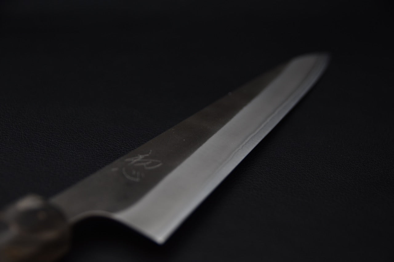 Détail de la lame d’un couteau japonais Sujihiki Yoshikane avec gravure et poli contrasté.