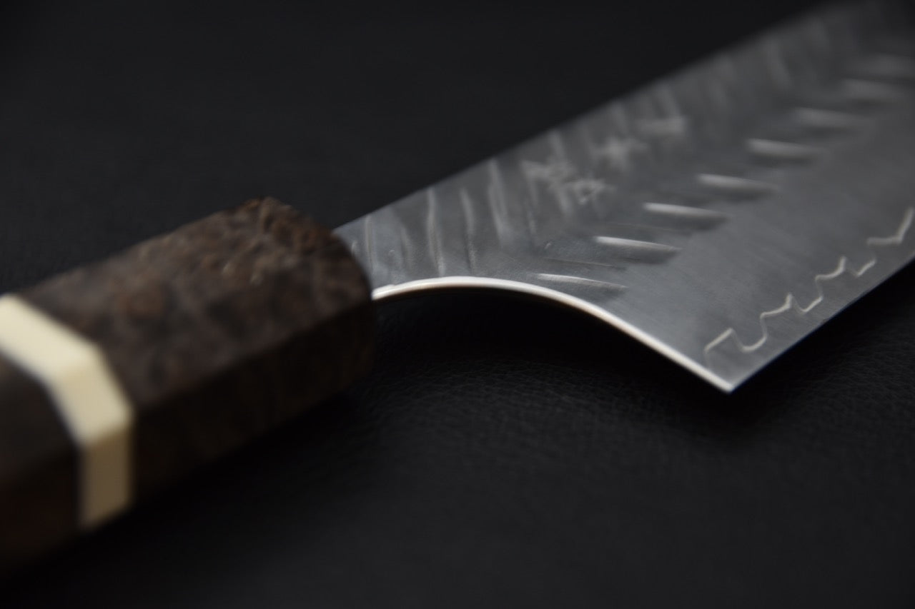 Épaisseur fine et tranchant d’un couteau japonais Kiritsuke vu de face.